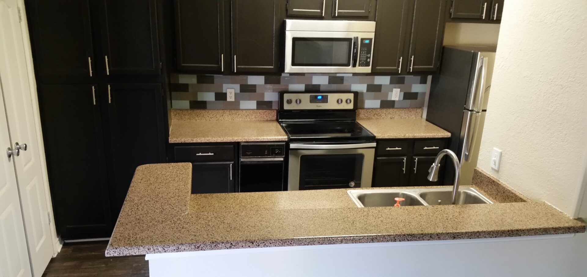 Modern kitchen with granite countertops and appliances.